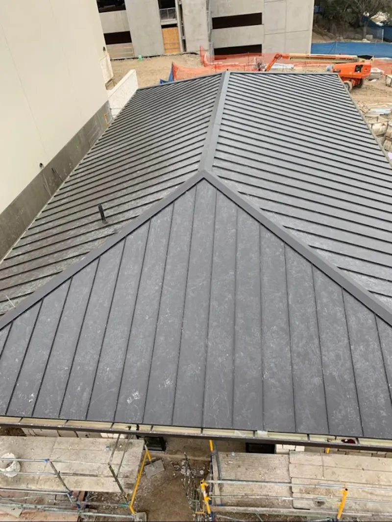 Commercial metal roof construction with crane equipment in Monticello